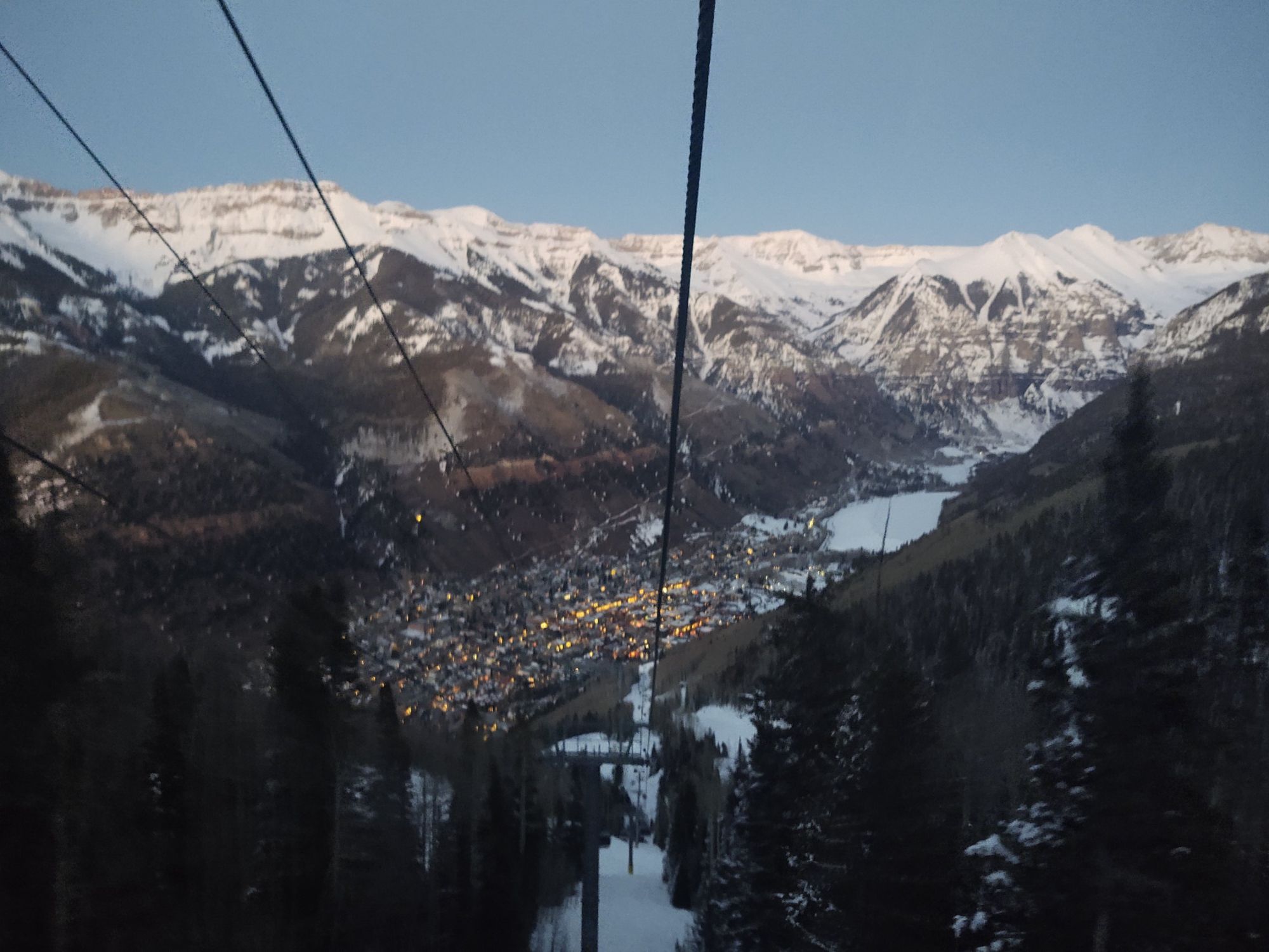 Gondola view over Telluride at dusk with snowy peaks